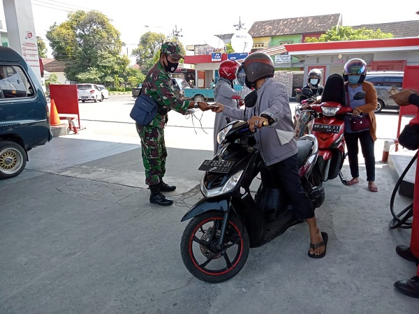 Babinsa Semanggi Mensosialisasikan PPKM Level IV dan Membagikan Masker di SPBU