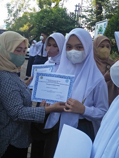 Kepala UPT SMP Negeri 7 Medan Dra Hj Irnawati MM, secara simbolis menyerahkan sertifikat juara kepada siswa Kelas 8.8 Hafiza Syakirah