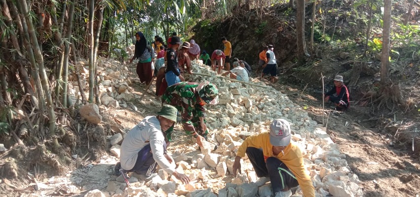 Babinsa Bantu Warga Binaannya dalam Perbaikan Jalan Desa dengan Karya Bakti